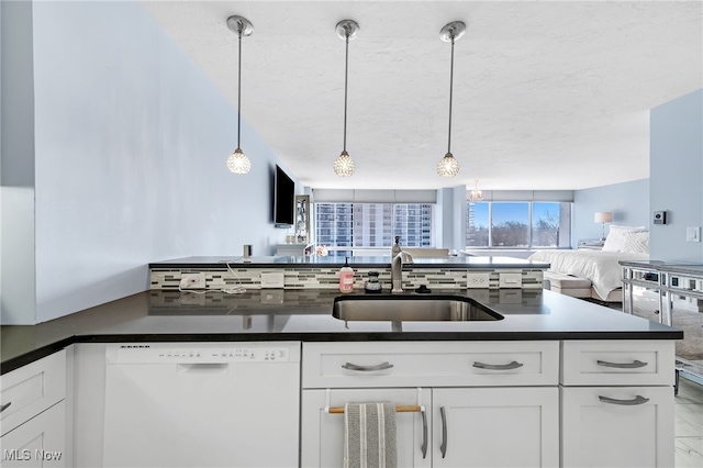 kitchen with sink, white cabinets, dishwasher, and hanging light fixtures