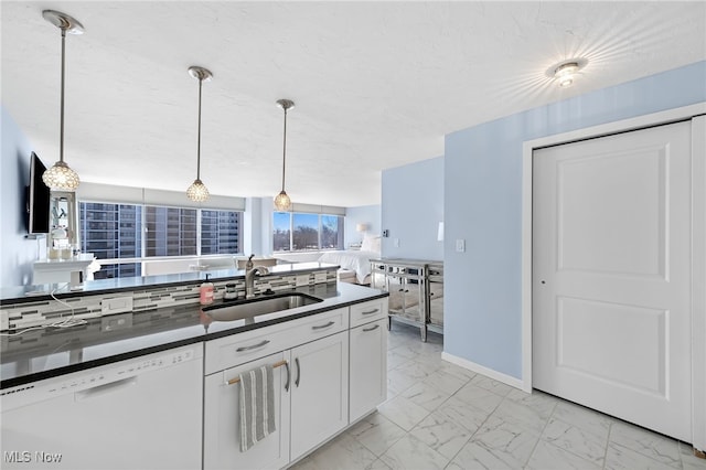 kitchen with sink, white cabinets, dishwasher, and hanging light fixtures