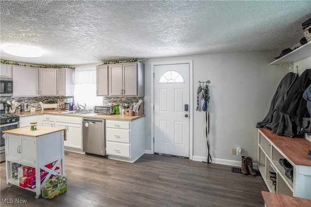 kitchen featuring sink, white cabinets, decorative backsplash, and appliances with stainless steel finishes