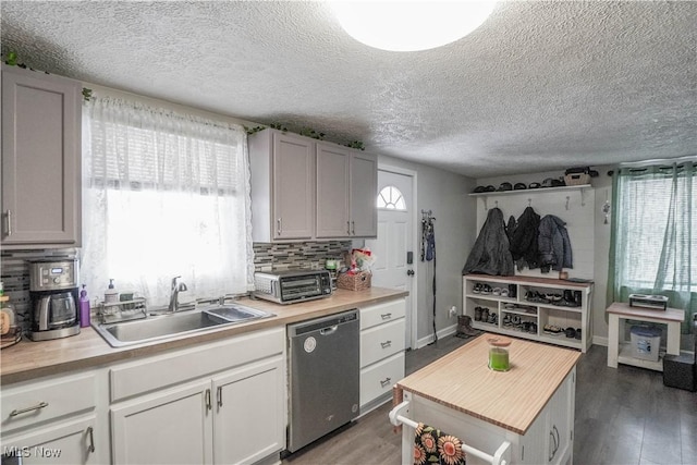 kitchen with sink, dark hardwood / wood-style floors, dishwasher, and a wealth of natural light