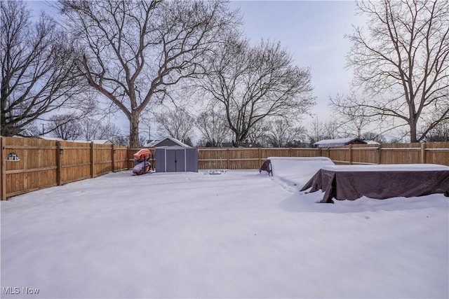 yard layered in snow with a storage shed