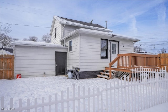 snow covered house featuring a deck