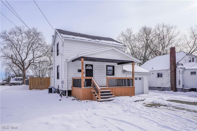 bungalow-style house featuring a garage and central AC