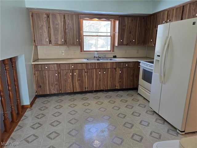 kitchen featuring sink, dark brown cabinets, and white appliances