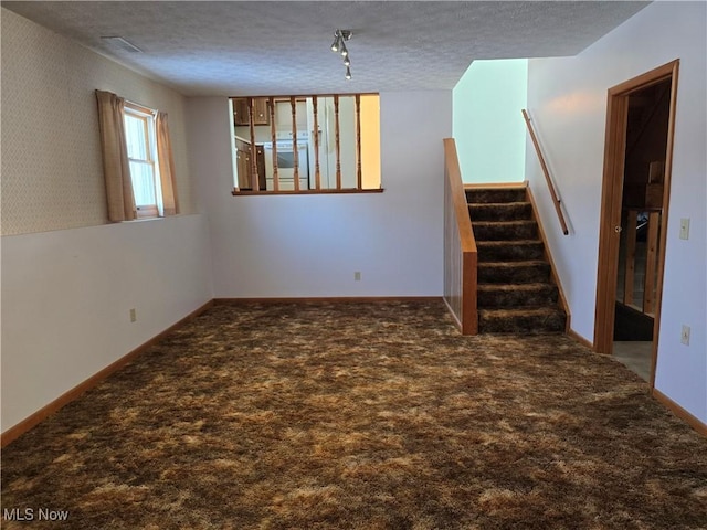 spare room with a textured ceiling and carpet floors