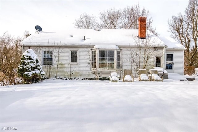 view of snow covered rear of property