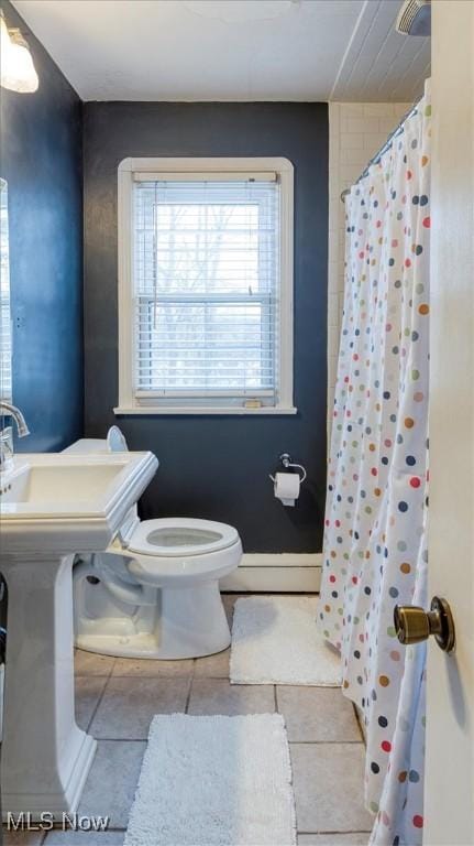 bathroom with toilet, tile patterned flooring, and walk in shower