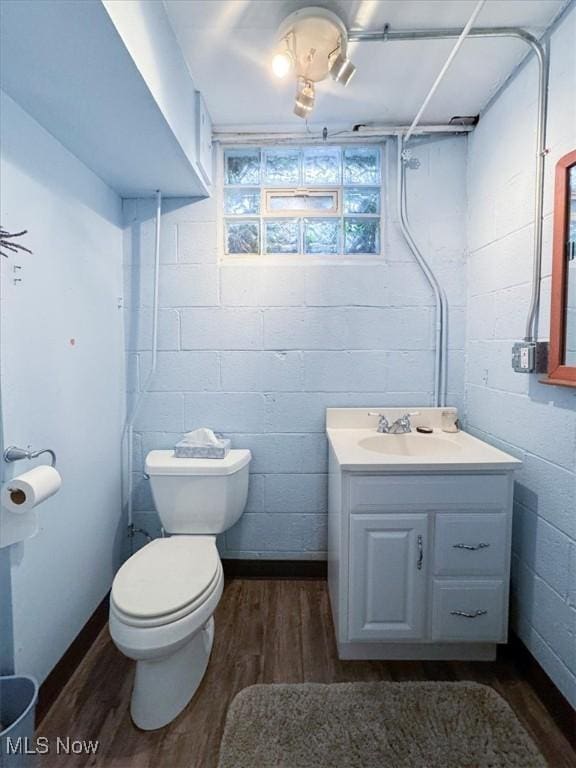 bathroom featuring wood-type flooring, toilet, and vanity