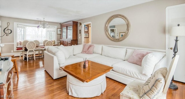 living room featuring an inviting chandelier and light wood-type flooring