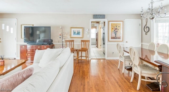 living room with light wood-type flooring and a chandelier