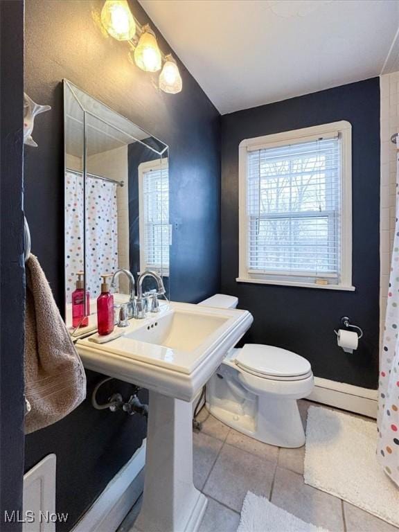 bathroom featuring toilet, walk in shower, tile patterned floors, and plenty of natural light