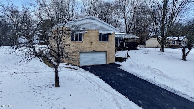 snow covered property with a garage