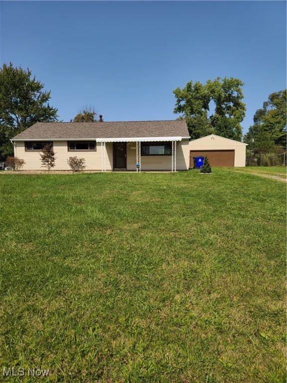 ranch-style house with a garage and a front lawn