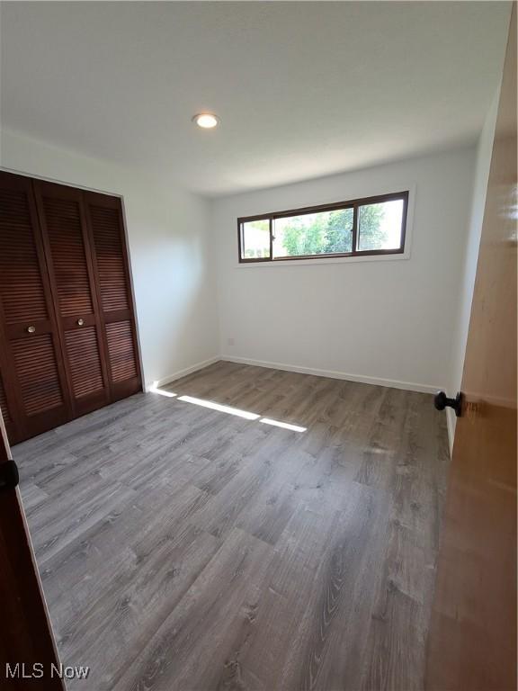 unfurnished bedroom featuring a closet and light wood-type flooring