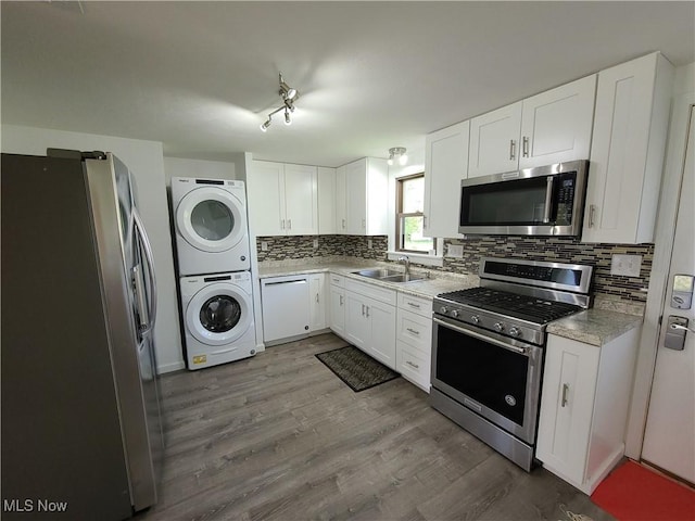 kitchen featuring white cabinets, stainless steel appliances, and stacked washer / drying machine