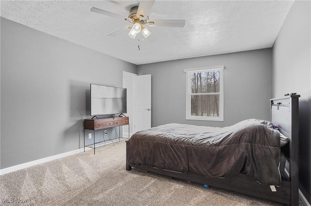 bedroom with a textured ceiling, carpet floors, and ceiling fan