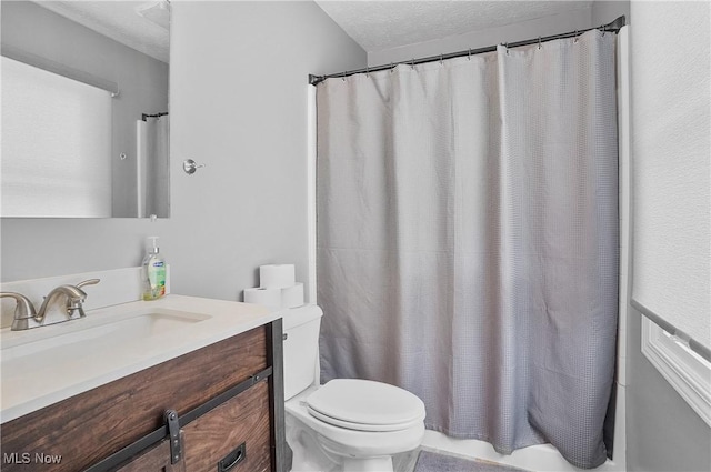 bathroom with vanity, toilet, a textured ceiling, and a shower with shower curtain