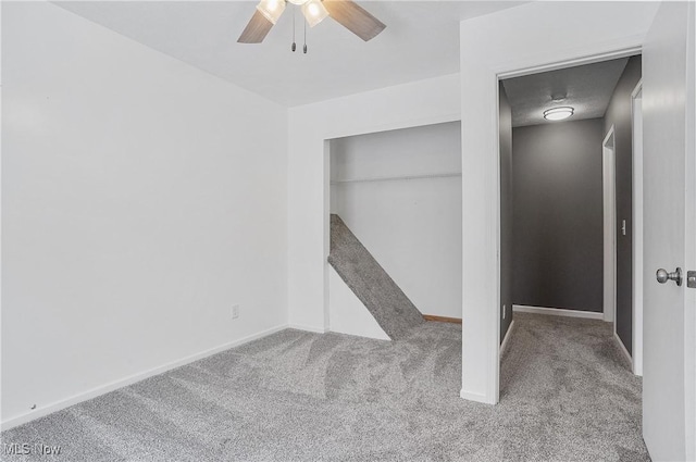 empty room featuring ceiling fan and light colored carpet