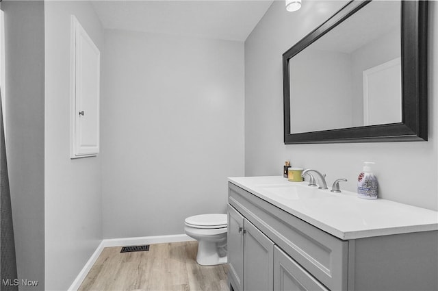 bathroom featuring hardwood / wood-style floors, toilet, and vanity