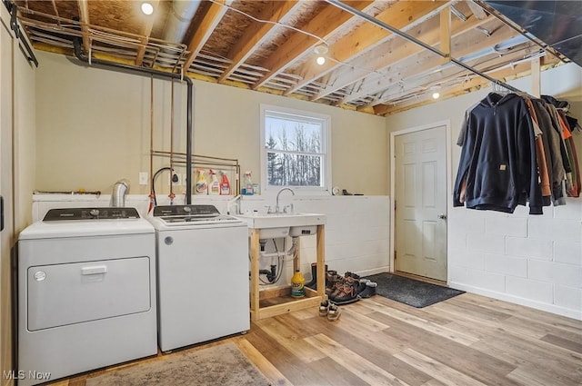 washroom with sink, light wood-type flooring, and washing machine and clothes dryer