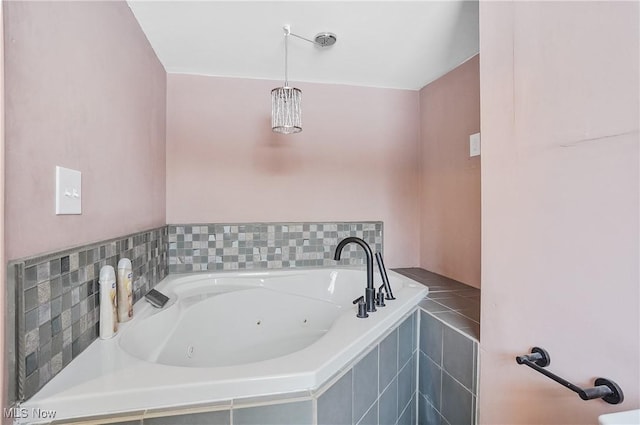 bathroom featuring a relaxing tiled tub and tile patterned flooring