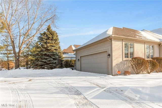 view of snow covered exterior with a garage