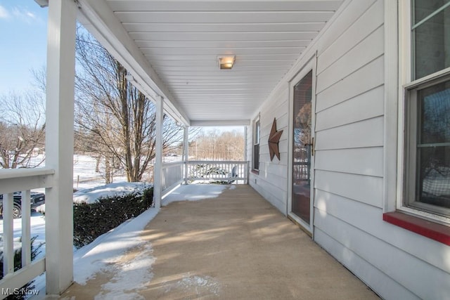 snow covered patio featuring covered porch