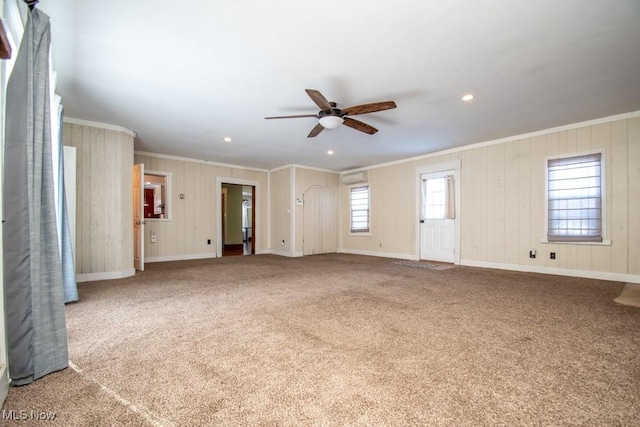 unfurnished living room with crown molding, carpet flooring, and ceiling fan