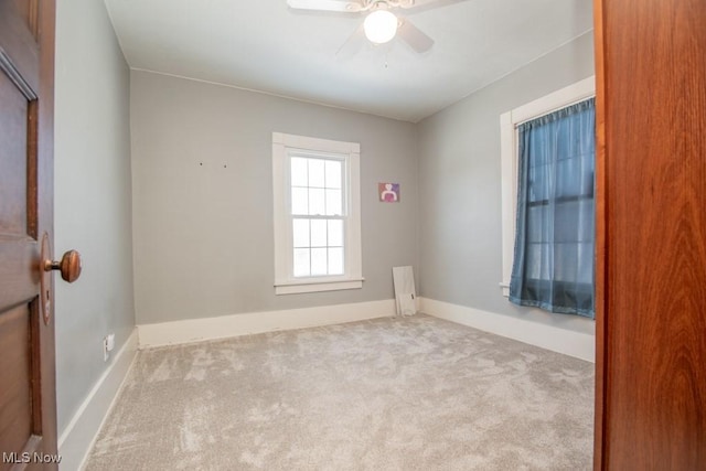 spare room with ceiling fan and light carpet