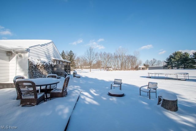 snowy yard with a trampoline