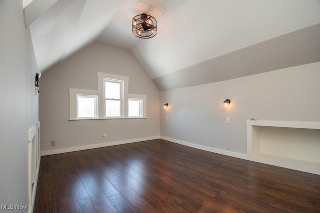 additional living space with dark hardwood / wood-style flooring and lofted ceiling