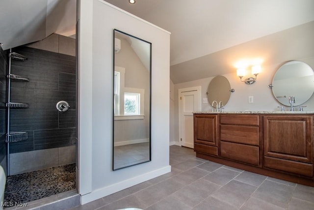 bathroom featuring tiled shower, tile patterned floors, lofted ceiling, and vanity