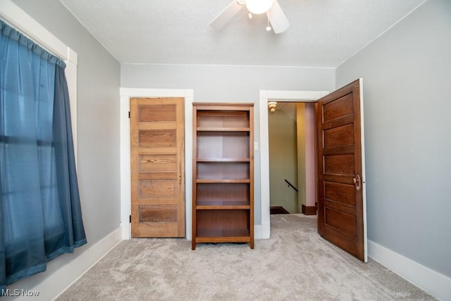 unfurnished bedroom with ceiling fan and light carpet