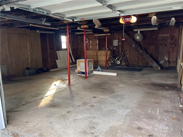 garage with a garage door opener and wooden walls