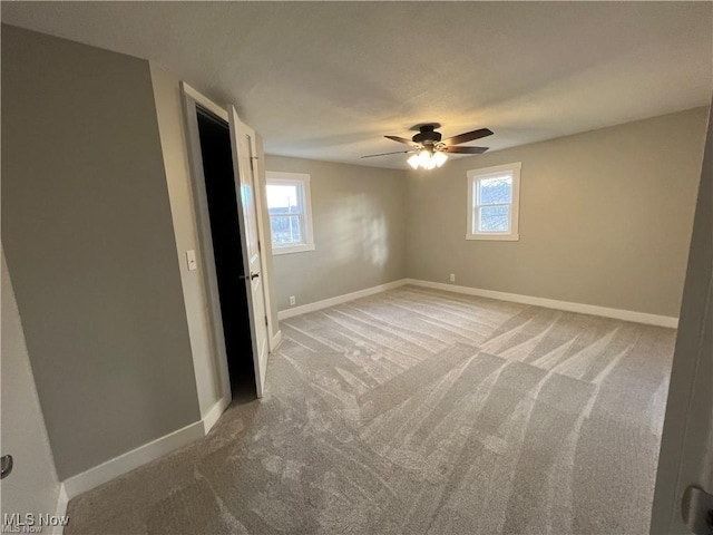 unfurnished room with ceiling fan and carpet flooring