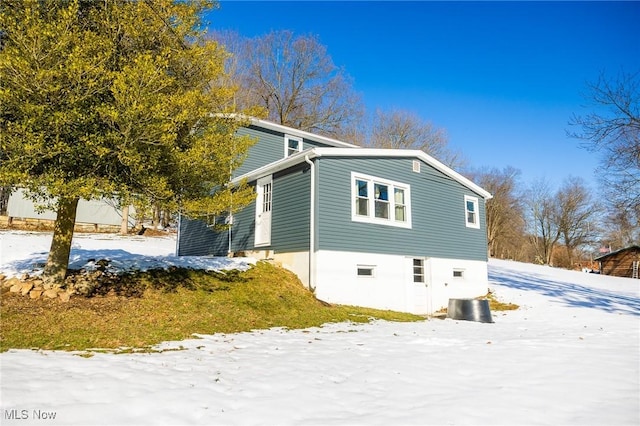 view of snowy exterior featuring central AC unit