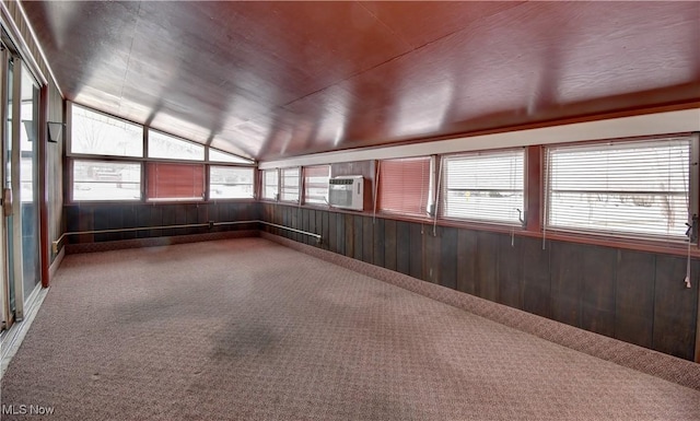 carpeted spare room featuring vaulted ceiling, wood walls, wooden ceiling, and a wall unit AC