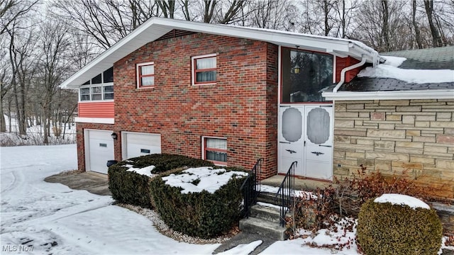 snow covered property featuring a garage