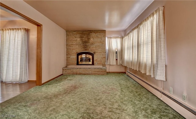 unfurnished living room with a fireplace, carpet, and a baseboard heating unit