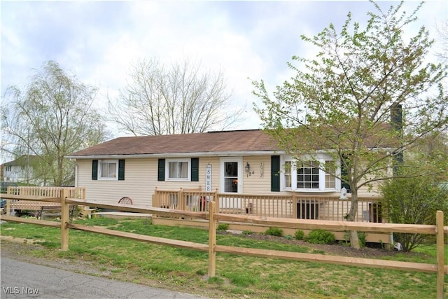 ranch-style home with a deck and a front yard