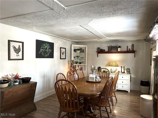 dining room featuring a textured ceiling and dark hardwood / wood-style floors