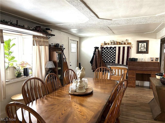 dining room with a textured ceiling and dark hardwood / wood-style flooring