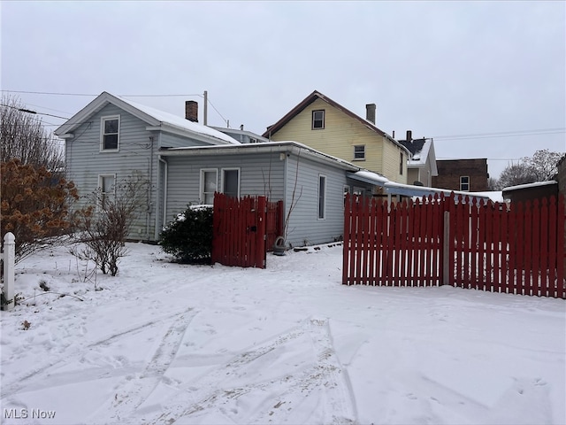 view of snow covered rear of property