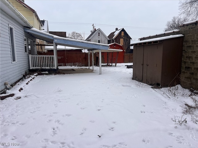 snowy yard with a storage shed