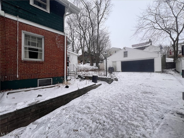 yard covered in snow with a garage and an outbuilding