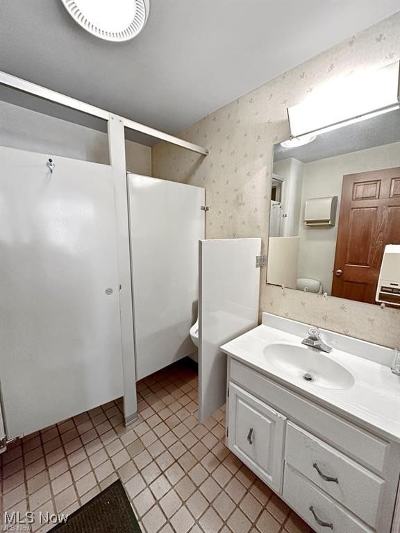 bathroom with vanity, toilet, and tile patterned flooring