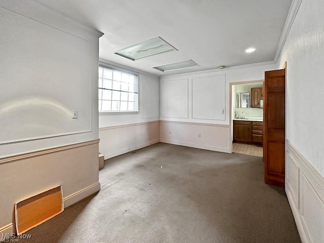 spare room with crown molding and dark colored carpet