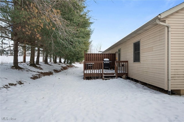 yard layered in snow with a wooden deck