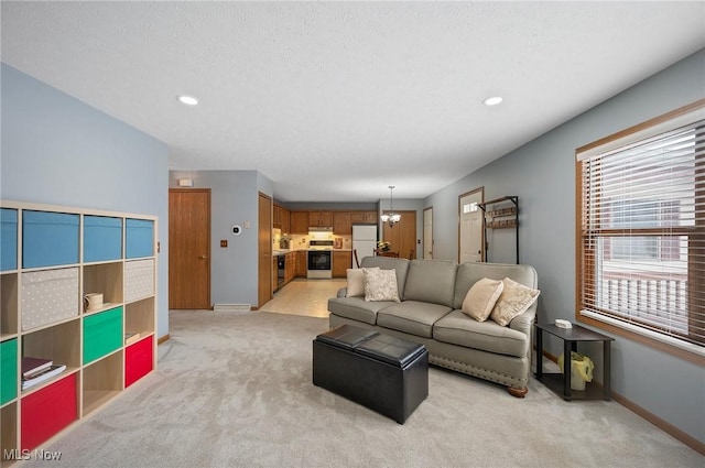 living room featuring a textured ceiling, light carpet, and a notable chandelier