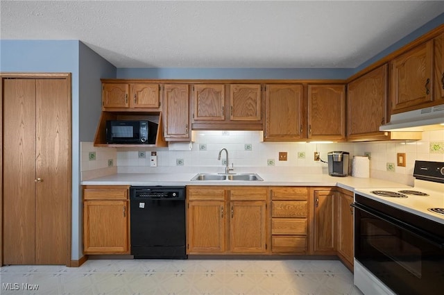 kitchen featuring black appliances, a textured ceiling, decorative backsplash, and sink